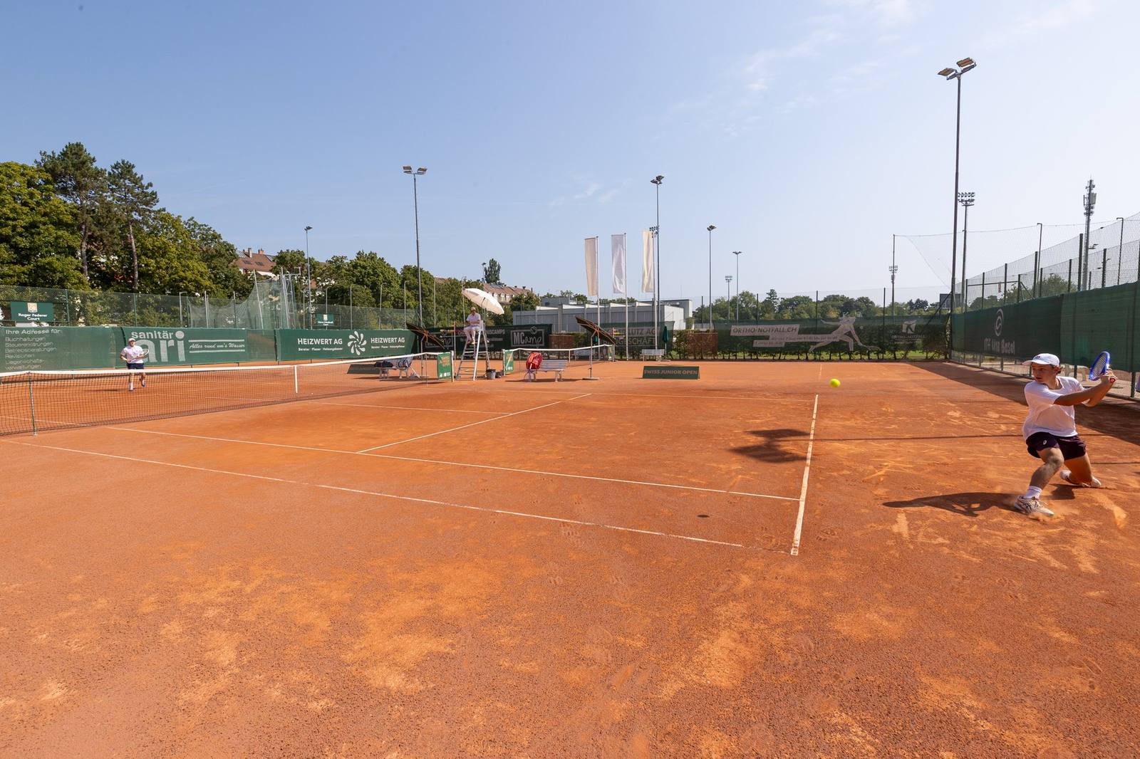 Juniorenspieler beim Rückhand-Return auf dem Sandplatz des Swiss Junior Open am TC Old Boys Basel